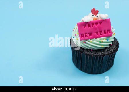 2017 Neujahr Huhn Cupcake auf blauem Hintergrund mit Textfreiraum Stockfoto