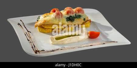 Hähnchenfilet mit gebratenen Karte und gegrillter Käse serviert auf einer Platte auf einem grauen Hintergrund isoliert Stockfoto