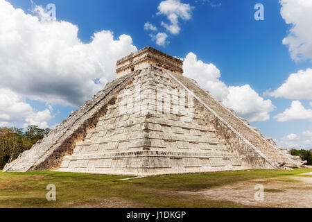 Unter einem strahlend blauen Himmel mit großen Wolken stehen in der antiken Maya-Stätte, bekannt als Chechen Itza El Castillo, eine riesige Maya-Pyramide. Stockfoto