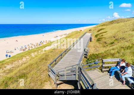 Menschen sitzen auf Küstenpromenade entlang Strand in Wenningstedt Stadt, Insel Sylt, Deutschland Stockfoto