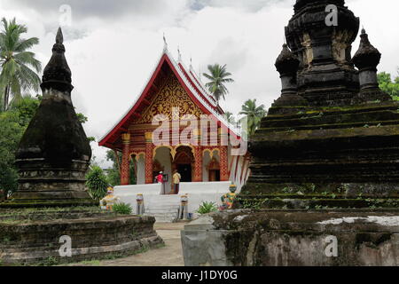 Luang Prabang, Laos-October 10, 2015: Touristische Couple Visits Sim-Congregation Hall of Wat Aham. Wächter-Tiger und Hanuman und Ravana von Phra La Stockfoto