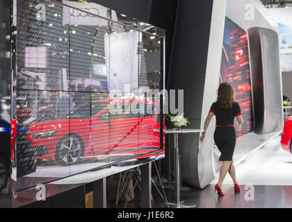 Manhattan, New York, USA. 12. April 2017. Reflexion der rote Audi Sport Auto ist auf große Glasscheibe, als Frau vorbei an der New York International Auto Show, quickly, im Javits Center geht sehen. Bildnachweis: Ann Parry/ZUMA Draht/Alamy Live-Nachrichten Stockfoto