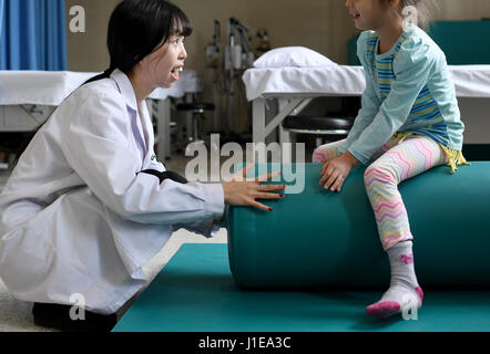 (170421)--URUMQI, 21. April 2017 (Xinhua)--Rehabilitation Therapeuten Min Xiaojuan (L) hilft eines der Zwillingsmädchen mit Aufbautraining der sechs Affiliated Hospital von Xinjiang medizinischen Universität in Urumqi, der Hauptstadt von Nordwesten Chinas Xinjiang Uygur Autonome Region, 17. April 2017. Die sechs-jährigen Zwillinge aus Usbekistan der infantilen Zerebralparese diagnostiziert, als sie im November 2016 nach China kam, können nicht beide laufen unabhängig und klar auszudrücken. Nach der Behandlung mit Akupunktur, therapeutische Massage, Kräutermedizin und Rehabilitationstherapie, konnten die Zwillinge Independe gehen. Stockfoto