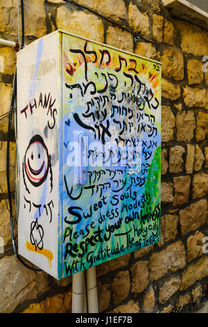 SAFED, ISRAEL - 17. November 2015: Eine Kommunikation-Box mit einem Graffiti über Bescheidenheit Kleid der Frauen in Safed (Tzefat), Israel Stockfoto