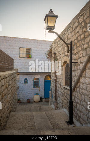 SAFED, ISRAEL - 14. September 2016: Eine Gasse im jüdischen Viertel der Altstadt, bei Sonnenuntergang, mit verschiedenen Zeichen in Safed (Tzefat), Israel Stockfoto