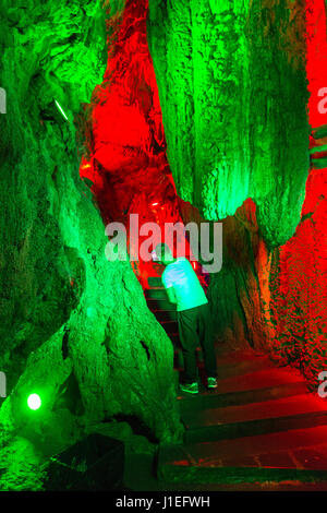 Provinz Guizhou, China.  Gelbe Frucht Baum (Huangguoshu) Wasserfall Naturgebiet.  Touristen fotografieren bunten Lichtern in Höhle hinter den Wasserfällen. Stockfoto