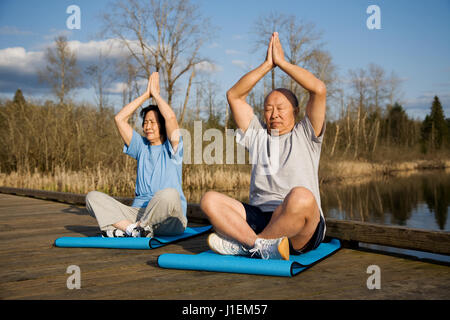 Ein älteres paar asiatische Meditation und Yoga zu praktizieren Stockfoto