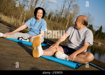 Ein senior asiatischen paar stretching vor dem Training Stockfoto