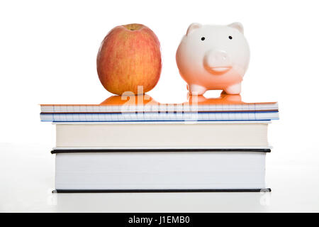 Ein Schuss von einen Apfel und ein Sparschwein auf Bücher, eignet sich für Bildungskonzept Stockfoto