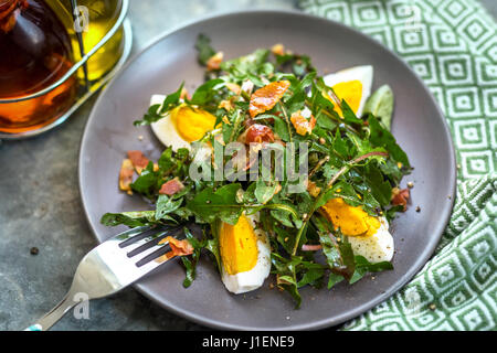 Löwenzahn-Salat mit Eiern und Speck Stockfoto