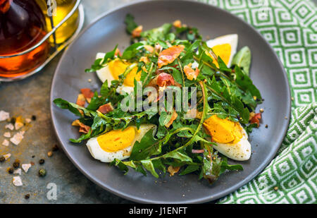 Löwenzahn-Salat mit Eiern und Speck Stockfoto