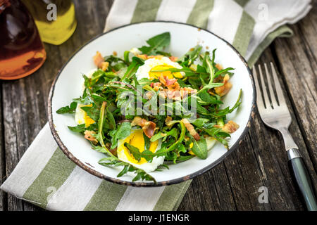 Löwenzahn-Salat mit Eiern und Speck Stockfoto