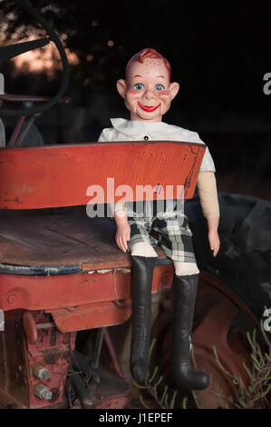 Howdy Doody Bauchredner Puppe sitzt auf einem alten Traktor. Stockfoto