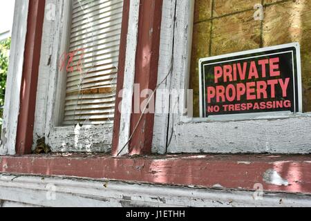 Privateigentum Schild am Haus mit zerbrochenen Fensterscheiben Stockfoto