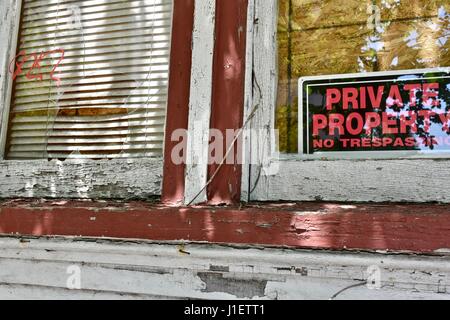 Privateigentum Schild am Haus mit zerbrochenen Fensterscheiben Stockfoto