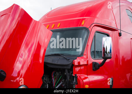 Riesige professionelle hell glänzenden modernen roten Sattelzug Semi LKW mit einem Hochdach-Fahrerhaus und öffnen der Haube, ein Bündel von Leitungen, Schläuche, Anschlüsse und andere Stockfoto