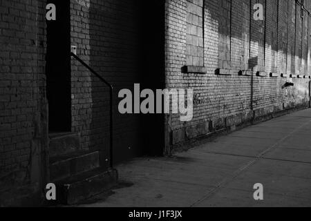 Alten Backstreet Gasse im DUMBO Brooklyn, New York zu Sonnenuntergang Monochrom, schwarz und weiß. Stockfoto