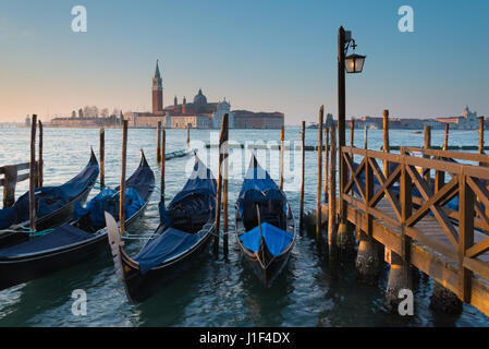 Blick über St Marks Becken zur Insel von San Giorgio Maggiore, Gondeln festgemacht entlang der Küste von St. Marks Platz, Venedig Stockfoto