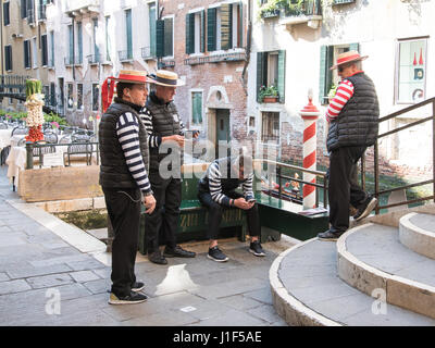 Gruppe von Gondolieri im Chat, während sie darauf, für das Geschäft in Venedig warten Stockfoto