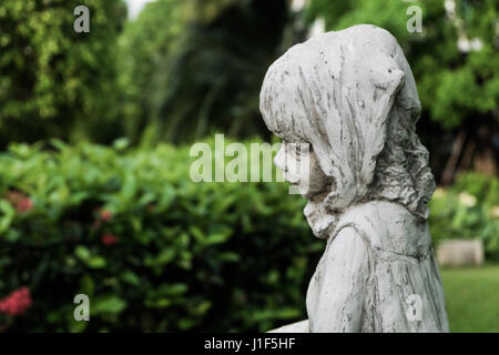 Eine weiße Vintage kleine Mädchen Keramik-Skulptur im Garten, selektiven Fokus. Stockfoto