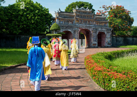 Vietnamesische Extras in traditionellen Kostümen durchlaufen Westtor, Chuong Duc, Imperial Palace Hoang Thanh, Verbotene Stadt Hue Stockfoto