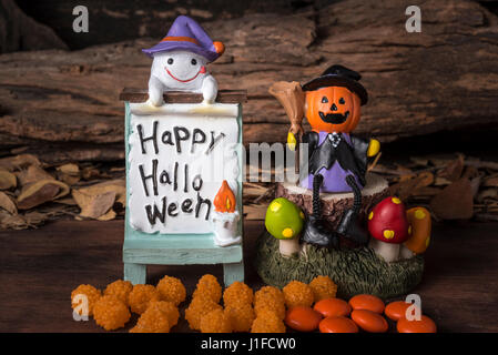 Kürbiskopf jack in Hexe Anzug auf Baum sitzend mit Ghost und happy Halloween-Board auf Wald backgroud Stockfoto