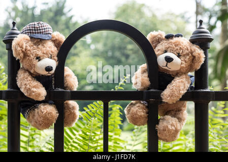 Teddy Bären hängen an einem Zaun im Park mit Kopie Raum, Liebe und Freundschaft Konzept im Vintage-Stil Stockfoto