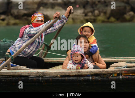 Fischers Familien in der Halong Bay zum Familieneinkommen beitragen, indem Sie mit Snacks und Souvenirs, die vorbeifahrenden Ausflugsboote. Stockfoto