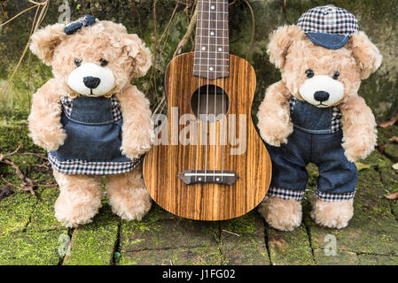 paar Teddybären mit Ukulele in Garten, Liebe und Freundschaft-Konzept Stockfoto