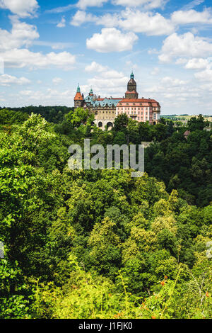 Zamek Ksiaz, eine Burg in Polen, gesehen von einem Aussichtspunkt mit einem Wald im Vordergrund. Stockfoto