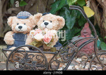 zwei Teddybären mit Rosen im Garten Hintergrund, Liebe Konzept Stockfoto