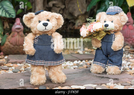 zwei Teddybären mit Rosen im Garten Hintergrund, Liebe Konzept Stockfoto