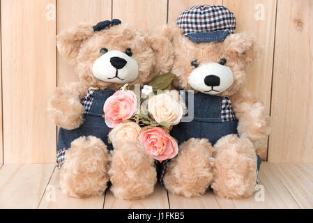 zwei Teddybären mit Rosen auf Holz Hintergrund, Liebe Konzept Stockfoto