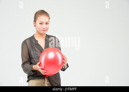 Glücklich schöne Asiatin mit den roten Ballon spielen. Stockfoto