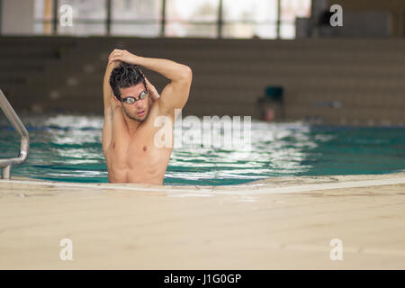Schwimmer im Poolwasser, streckte Arme drinnen. Stockfoto