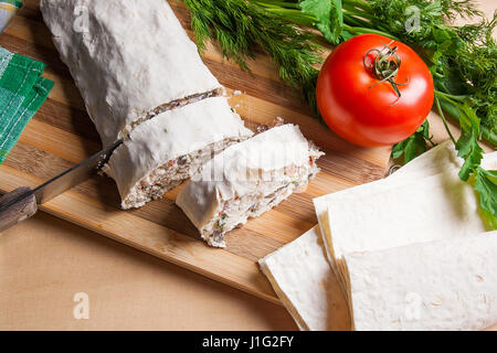 Stücke geschnittenen dünn armenische Fladenbrot oder Lavash gewickelt, Tomaten, Käse oder Quark, Hühnerfleisch, Tomaten und Kräuter - Dill, Zwiebel, Petersilie Stockfoto