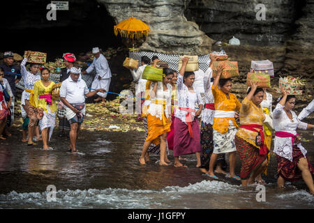 Balinesische Pilger mit angeboten zu Tanah Lot Tempel, die ihren Weg aus dem alten rock Tempel Pura Luhur während einer bunten Tempel-Jubiläum Stockfoto