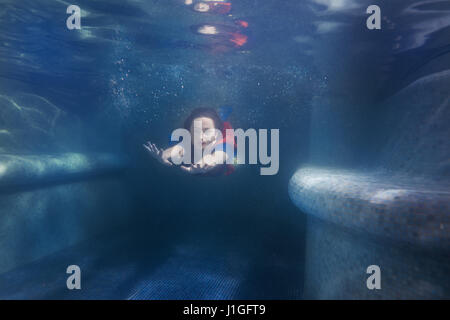 Frau schwimmt unter Wasser im Pool wie eine Meerjungfrau. Stockfoto
