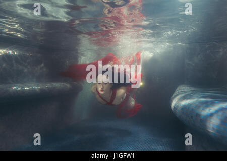 Damen Kleid entwickelt, sie schwimmt unter Wasser. Stockfoto
