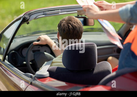 Glückliche Freunde mit Karte im Cabrio fahren Stockfoto