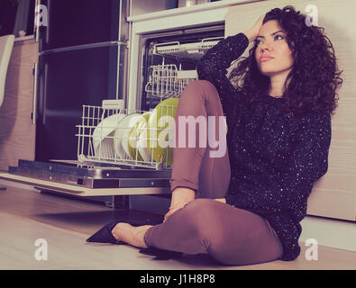 Entspannende gestresste Frau in der Küche sitzen auf einer Etage Stockfoto