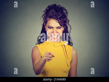 Porträt des jungen lächelnd Business-Frau im gelben Kleid Zeigefinger auf Betrachter auf graue Wand Hintergrund isoliert Stockfoto
