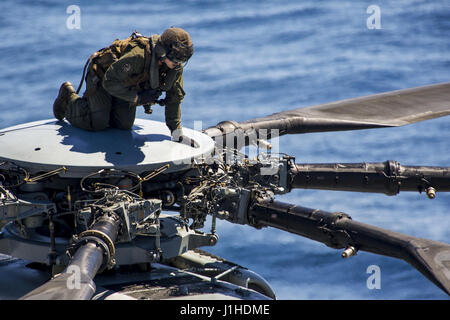 Eine Marine klettert an die Spitze der ein CH-53E Super Stallion, Wartung im Flugbetrieb durchzuführen Stockfoto