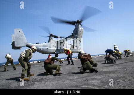 Matrosen und Marinesoldaten Klammer gegen Rotor waschen wie ein MV-22 Osprey Stockfoto