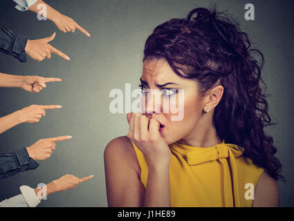 Ängstliche Frau von verschiedenen Leuten Finger zeigte auf ihr beurteilt. Konzept der Anklage schuldig Mädchens. Negative Emotionen Gesicht Ausdruck Gefühl Stockfoto