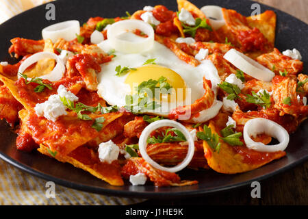 Mexikanisches Frühstück: Chilaquiles mit Ei und Huhn Nahaufnahme auf einer Platte. horizontale Stockfoto