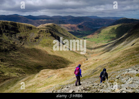 Männliche und weibliche Wanderer Abstieg von der High Street in Weiden unten U förmigen Tal in Richtung Hartsop, Patterdale und Ullswater im Lake District Stockfoto