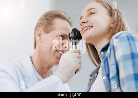 Lächelnd Arzt mit Dermatoskop bei Termin in der Klinik Stockfoto