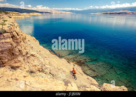 Mountainbiker am Fahrrad im Sommer inspirierende Berge und Meer Landschaft reiten. Mann Radsport MTB auf der Enduro Trail Strecke am Meer und felsigen Schmutz pat Stockfoto