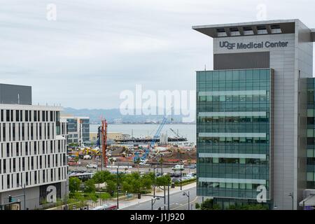 In diesem Luftbild sind Baukräne sichtbar auf der Website von Chase Center, das neue Stadion für die Golden State Warriors Basketball-Nationalmannschaft, mit der UCSF Medical Center sichtbar in den Vordergrund, Mission Bay, San Francisco, Kalifornien, 6. April 2017. Das Stadion-Standort ist umstritten, da gibt es Bedenken, dass die Stadion Verkehr zugenommen UCSFs nahe gelegenen Krankenhaus negativ beeinflussen. Stockfoto